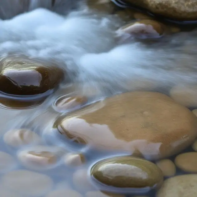 Water flowing over smooth stones, symbolizing peace and flow